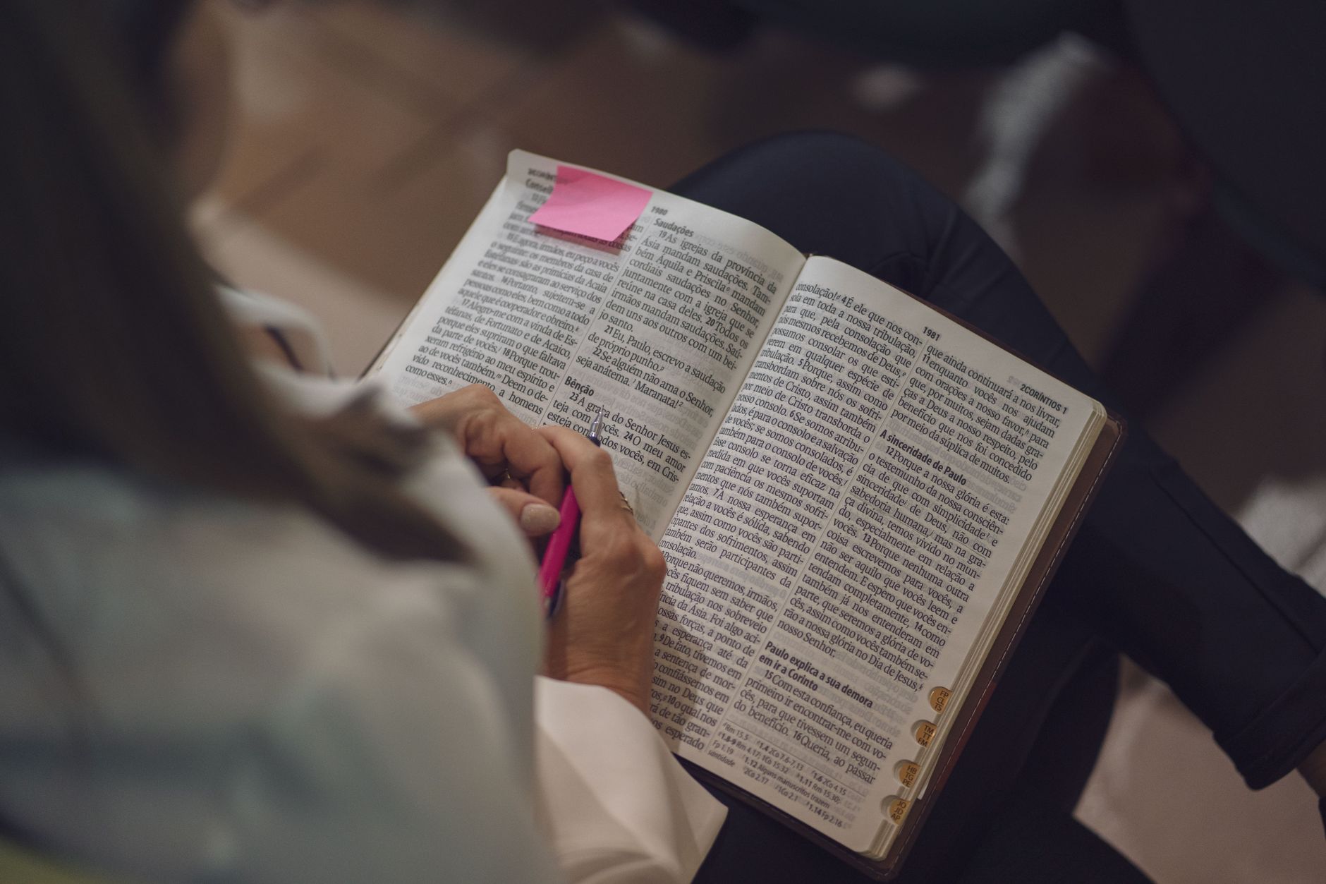 woman studying bible with pink note marker