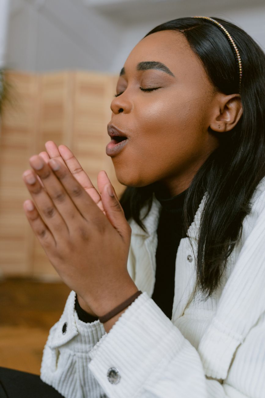 woman in white jacket praying