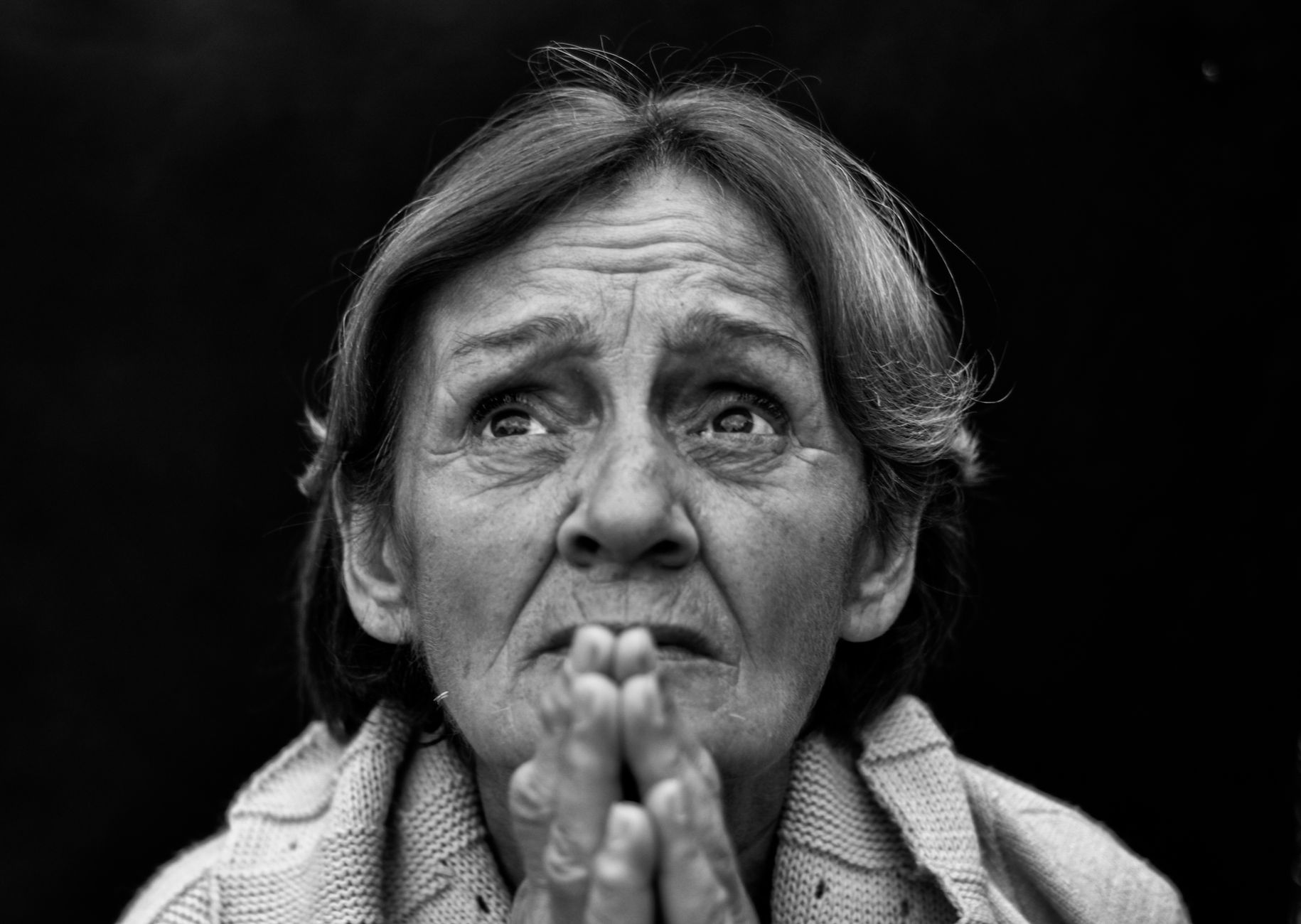 grayscale photography of a woman praying